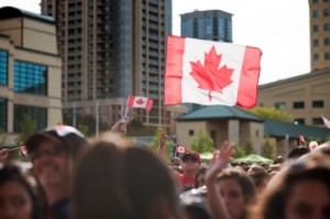 People gathering to celebrate Canada Day in Mississauga, Ontario, Canada, with Canadian flags fluttering across the scene