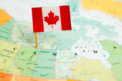 A Canadian flag is pinned in a map of Canada