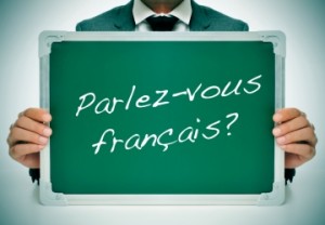 Man holding up a chalk board that says parlez-vous français?