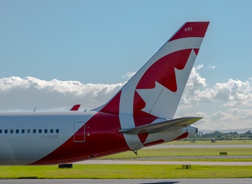 The tail of an Air Canada Rouge airplane, showing a maple leaf