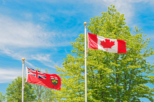 Canadian and Ontario flags on a windy day.