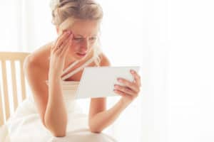Bride with a worried expression looking at tablet