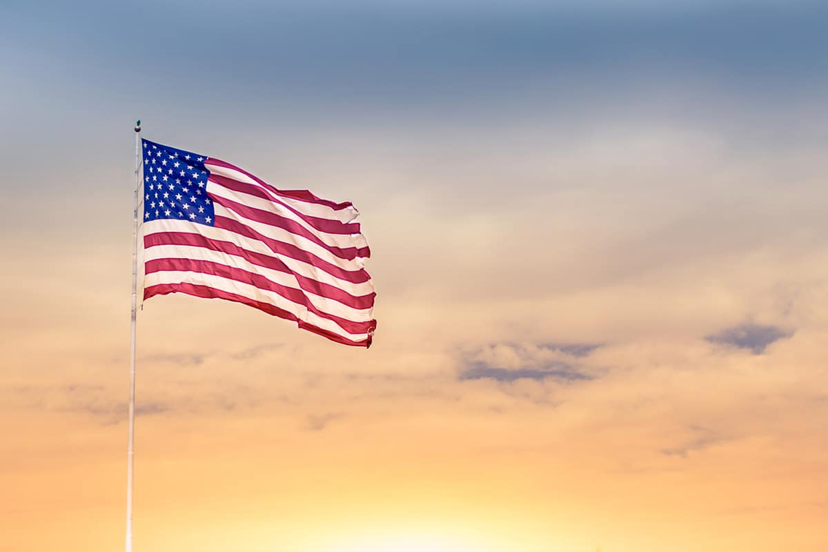 U.S. flag waving into the sunset.