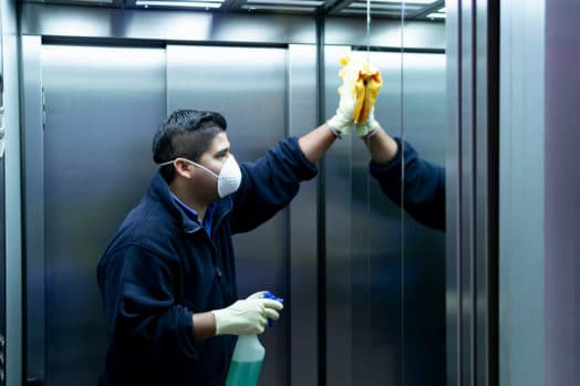 Man cleaning the inside of an elevator