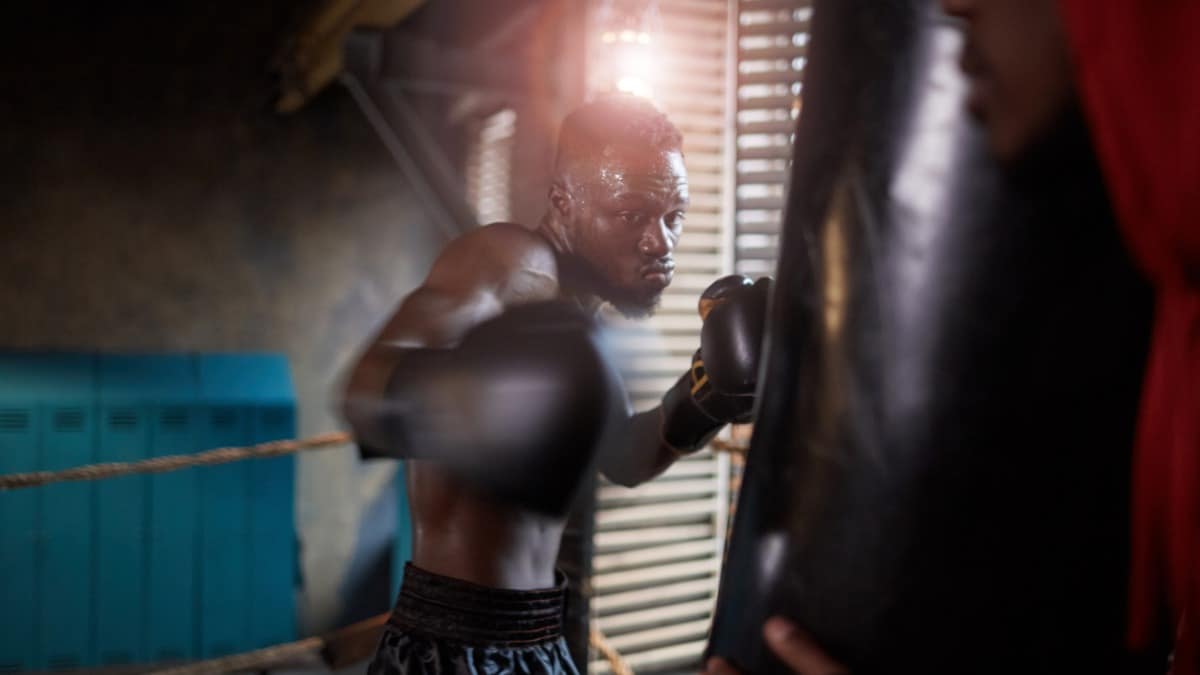 Boxer punches punching bag during training