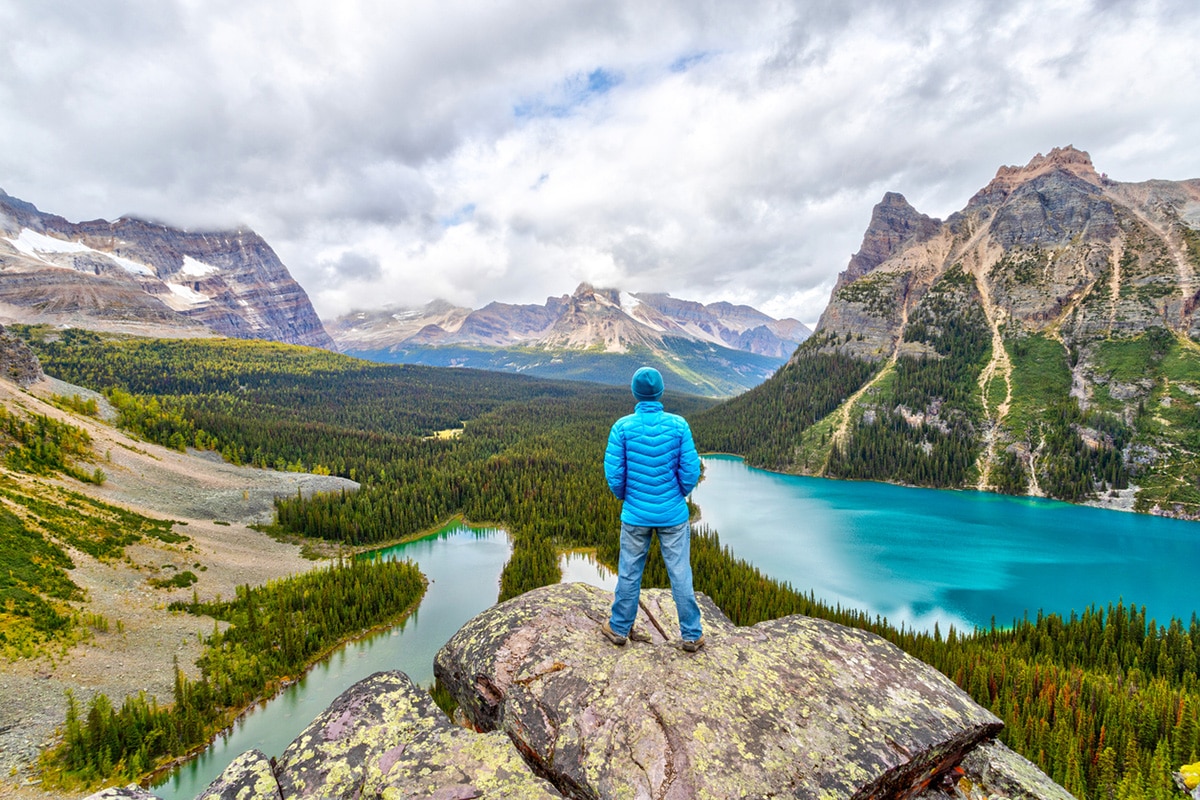 Man in coat overlooking Canadian mountains and lakes