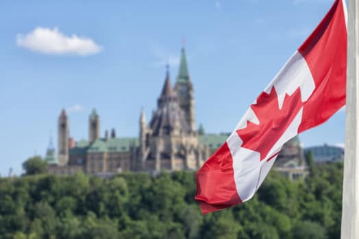 Canada flag waving in front of Parliament building in Ottawa
