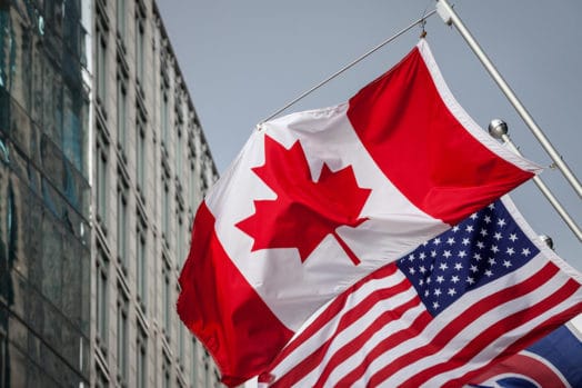 Canada flag in front of U.S. flag