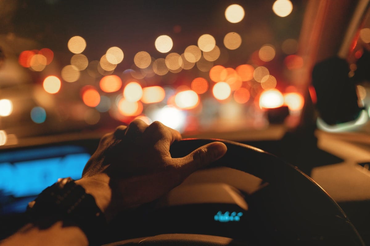 Close up of hand on a steering wheel, blurry vision out of window.