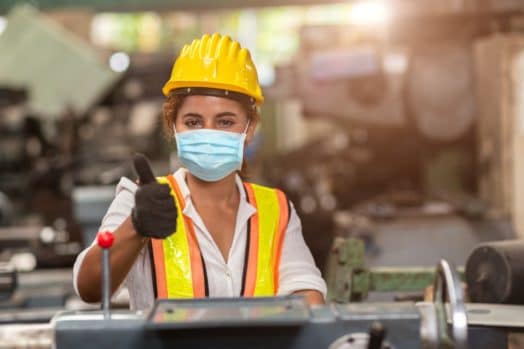 Essential worker wearing surgical mask giving thumbs up