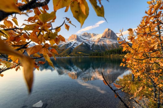 Sunrise on Mount Lawrence Grassi with golden leaves reflection on Rundle Forebay reservoir at Canmore
