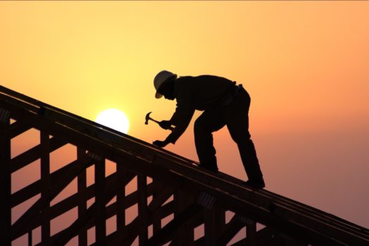 A roofer working during sunset.