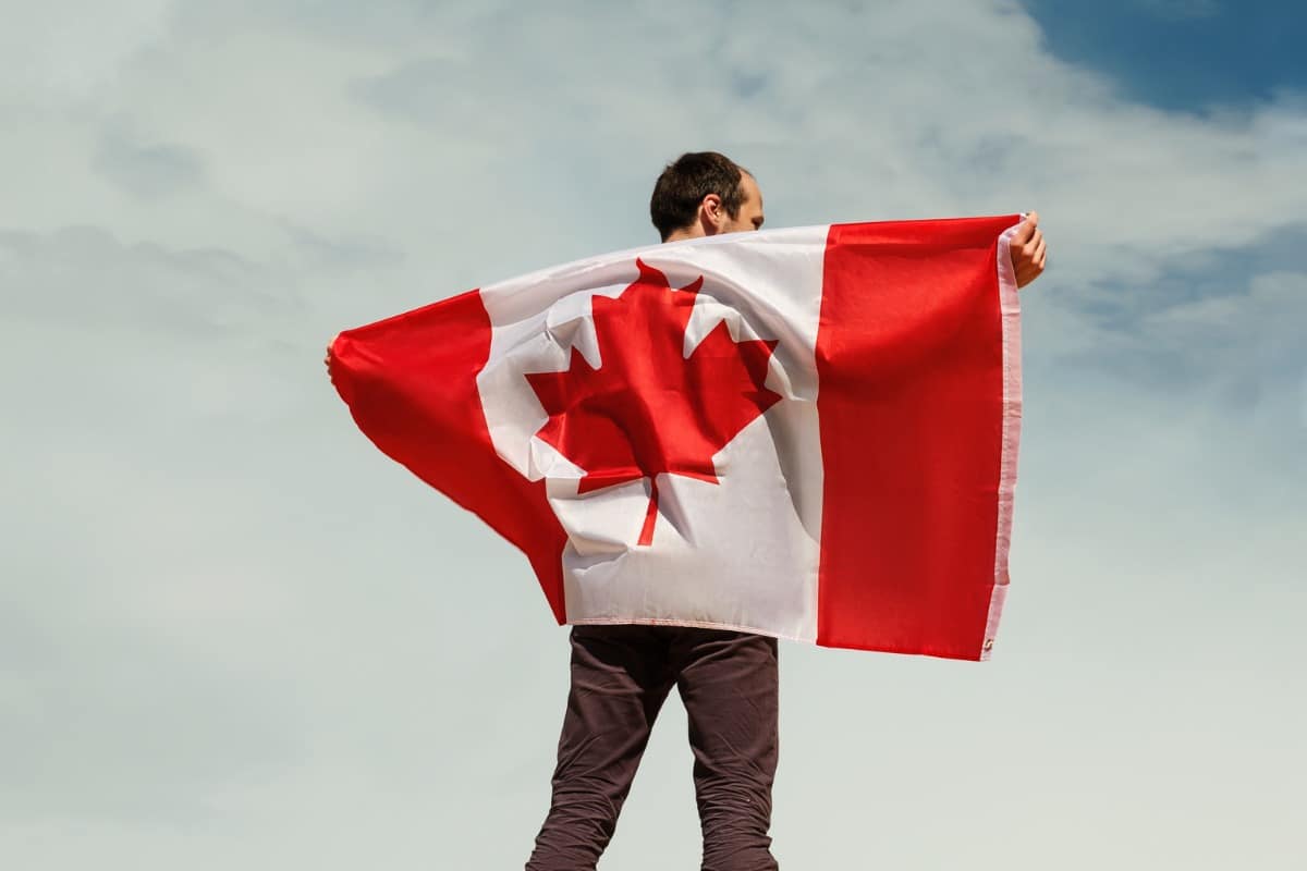 Man holds a Canadian flag across his back