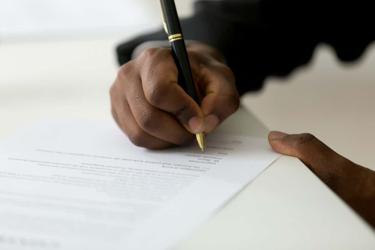 The hand of a lawyer signing a legal opinion letter.