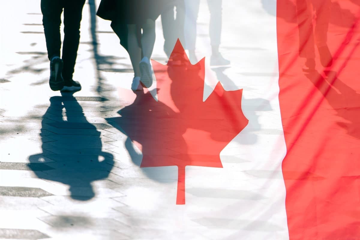 canadian flag with people's legs in the background