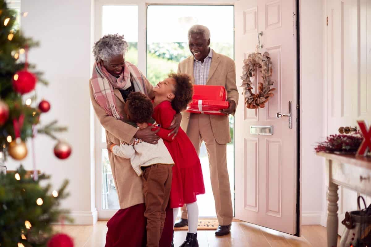 Two grandchildren greeting their grandparents at the door during the holidays