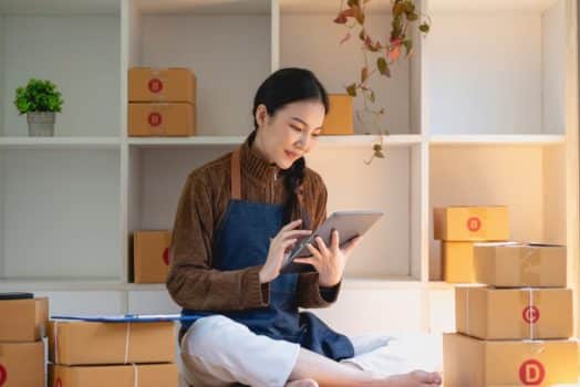 A woman sitting on a bed amid boxes. Canada's Start-Up Visa program is available to entrepreneurs looking to start and grow their businesses in Canada.