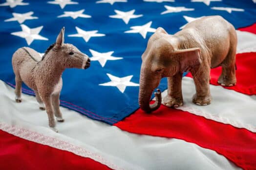 A donkey and an elephant on an American flag. The USA is one of the top source countries for new immigrants to Canada every year.