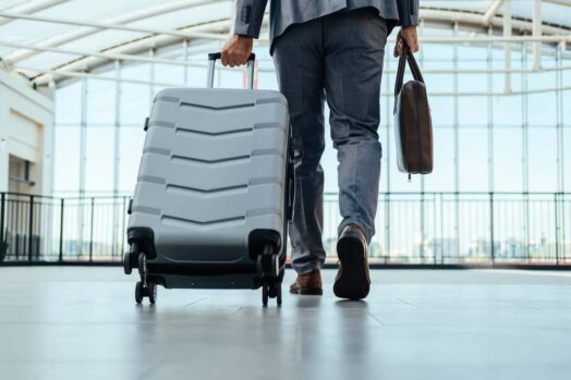 Una persona en un aeropuerto caminando con una bolsa con ruedas.  Canadá da la bienvenida a miles de trabajadores extranjeros al país cada año.