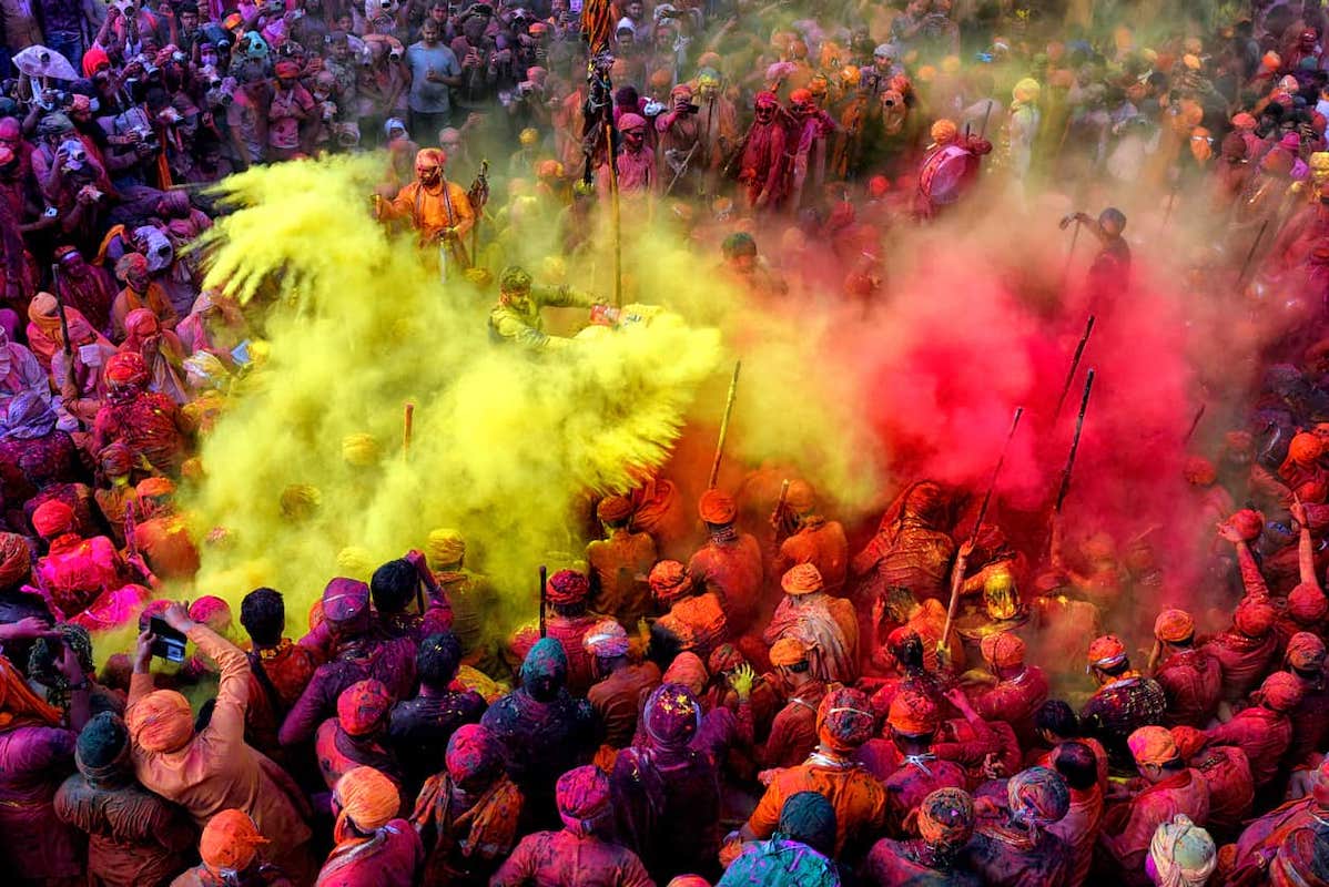 A large group of people celebrating Holi in the street. Indians represent the largest source country for new immigrants and citizens to and from Canada.
