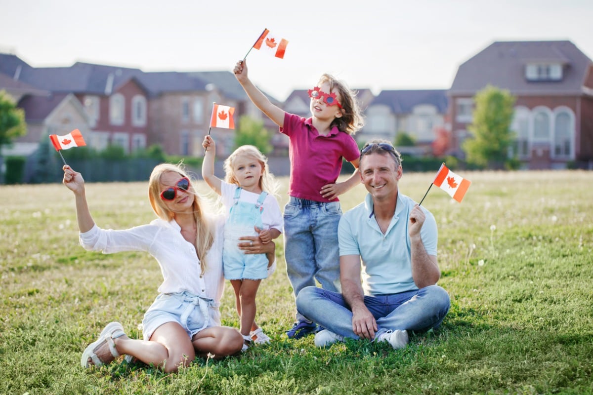 Family waving Canadian flabs