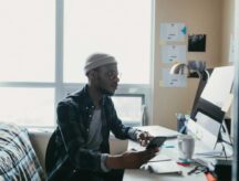 A young person sitting at a desk on their computer.