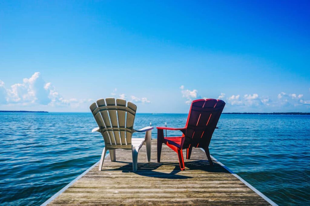 Two chairs face lakeside at the end of a pier. This week four provinces announced PNP draws.