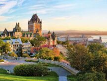 Panoramic view of Chateau Frontenac surrounded by greenery in Old Quebec, Canada at sunrise