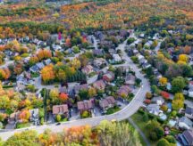 Aerial view of family homes in residential neighbourhood showing trees changing color during fall season in Montreal, Quebec, Canada