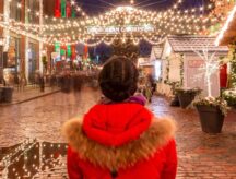 A woman admires the lights at night in Toronto's distillery district.