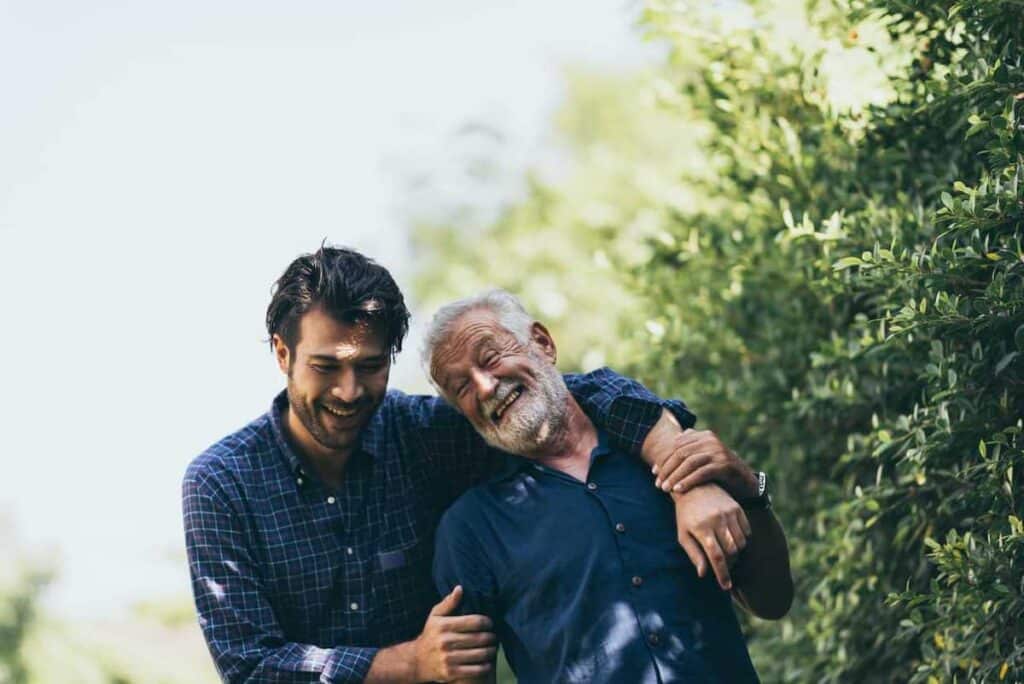 A man and his father taking a walk in a garden.
