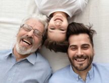 A man, son and grandfather lying down together.