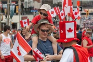 A father and son at a Canada day parade, surrounded by Canadian flags