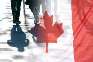 A picture of the Canadian flag imposed over people walking into the distance