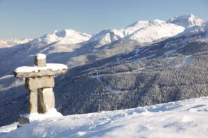 A view of the Canadian mountain range, with an indigenous sentry overlooking the view.