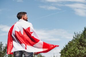 A man holds a Canadian flag across his back