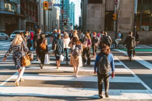 A crowd of people crossing the street in downtown Toronto (Adelaide St. W) during rush hour.