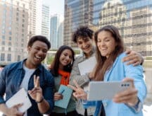 Group of diverse young adult students are posing together taking a selfie on a smartphone in the city