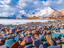 A group of colourful rocks at the base of a might mountain.