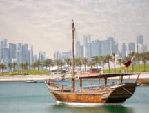 A view of the Qatari skyline with a dhow in the center foreground.