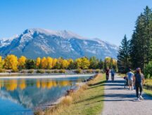 People walking along the Bow River riverside trail in autumn (Canmore, Alberta)