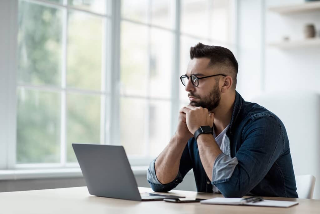 A man considers his CRS score at a laptop.