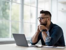 A man considers his CRS score at a laptop.