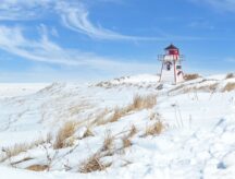 A lighthouse stands on the PEI coast during winter time.