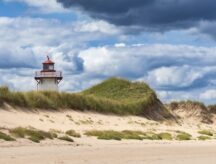 A lighthouse on the PEI coast, as a wind blows through the beach.