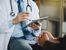 A person at the doctors office being consulted on their ailment.