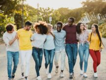 Eight individuals walking and laughing as they do so.
