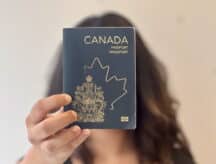 Woman holding Canadian passport up to camera.