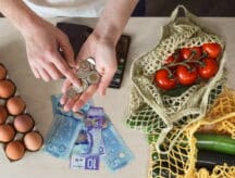 A woman counts here available expenses as she reviews her grocery purchase.