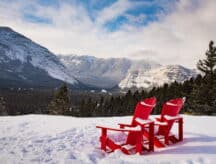 A pair of empty lawn chairs view the wide open mountain expanse.